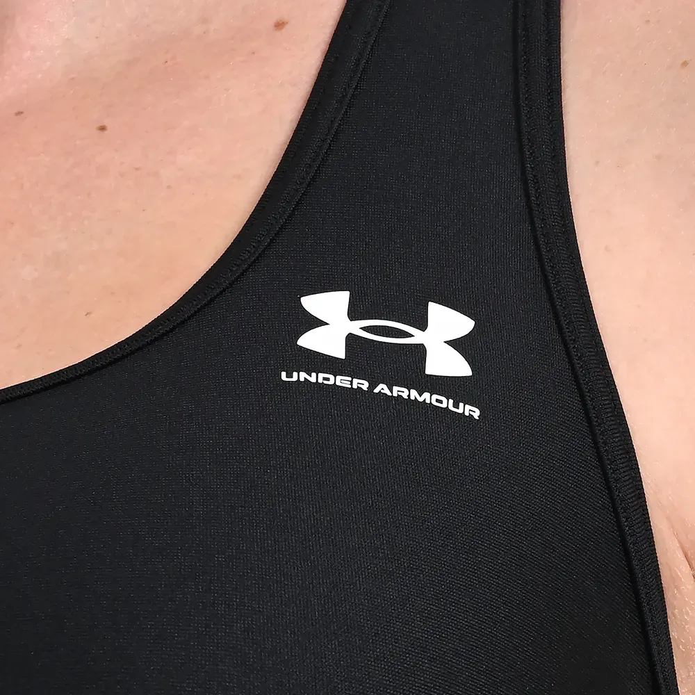 Top feminino Under Armour preto em fundo branco para ajuste e conforto
